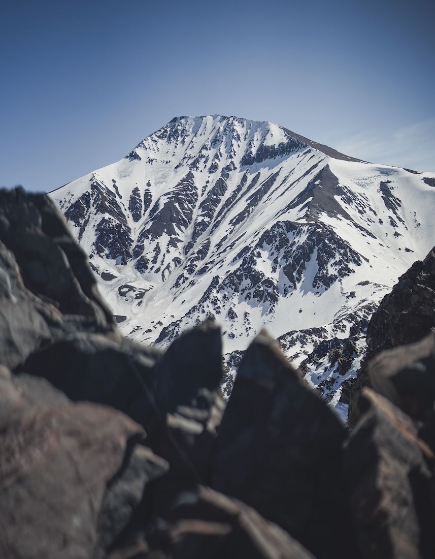 Snowy peak above rocky ridges